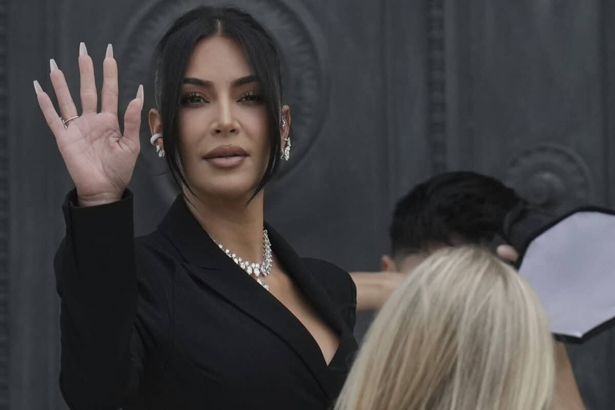 Kim Kardashian waves as she arrives to testify regarding a robbery